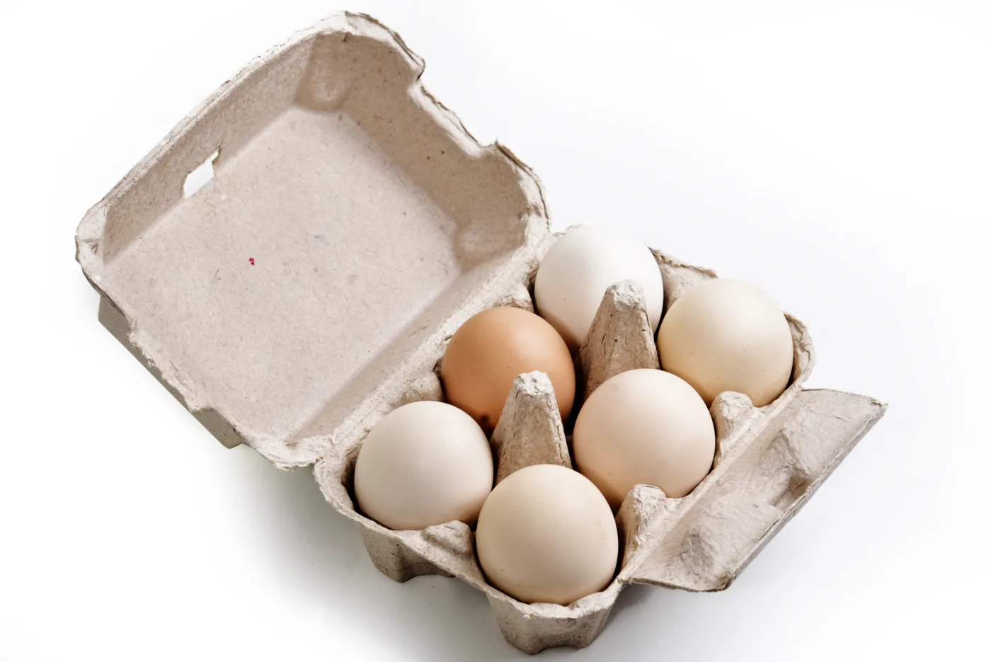 Open carton showing six desi eggs in natural shades